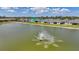 Wide view of a community pond with a fountain, surrounded by well-maintained lawns and homes at 1607 Laurel Brook Ln, Port Charlotte, FL 33953