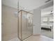 Modern shower featuring tan tiling, a glass door, and chrome hardware at 1607 Laurel Brook Ln, Port Charlotte, FL 33953