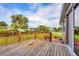 Wooden back deck overlooking a lush yard with palm trees and well-maintained landscaping at 1795 Walden Ct, Englewood, FL 34224