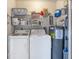 A fully functional laundry room featuring a washer, dryer, shelving, and water heater for convenience at 182 Rotonda W Blvd # B, Rotonda West, FL 33947