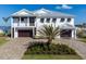 Elegant two-story home with a manicured lawn, paver driveway, and a symmetrical facade with a two-car garage at 1926 Georgia Ave, Englewood, FL 34224