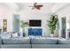 Comfortable living room with a blue sectional sofa, custom blue media cabinet, and tropical plants at 1926 Georgia Ave, Englewood, FL 34224