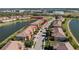 Aerial view of townhomes with waterfront location, tile roofs, and tropical landscaping at 20231 Lagente Cir, Venice, FL 34293
