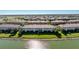 Aerial view of the townhome community with lake, landscaping, and waterfront properties at 20231 Lagente Cir, Venice, FL 34293