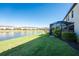 Water view backyard featuring green lawn, landscaping, and screened in porch at 20231 Lagente Cir, Venice, FL 34293