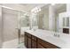 Primary bathroom featuring double sinks, a large mirror, and a shower with sliding glass doors at 20231 Lagente Cir, Venice, FL 34293