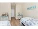Bedroom featuring two twin beds, beach themed decor, and a view into the home's hallway at 20231 Lagente Cir, Venice, FL 34293