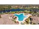 Aerial view of community pool and clubhouse with patio seating and lake views at 20231 Lagente Cir, Venice, FL 34293