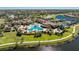 Aerial shot of a resort-style pool with palm trees, a clubhouse, and ample seating at 20231 Lagente Cir, Venice, FL 34293
