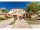 Townhome exterior with paver driveway, tropical plants, and a one-car garage at 20231 Lagente Cir, Venice, FL 34293