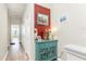 Bright hallway with colorful decor including artwork, lamps, and a turquoise side table with glass doors at 20231 Lagente Cir, Venice, FL 34293