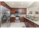 Well-lit kitchen featuring stainless steel appliances, wooden cabinetry, and granite countertops at 20231 Lagente Cir, Venice, FL 34293