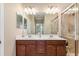 Bathroom with double sink vanity, large mirror, and walk-in shower at 20279 Lagente Cir, Venice, FL 34293