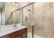 Bathroom featuring tile shower, glass doors, wood vanity and white sink at 20279 Lagente Cir, Venice, FL 34293
