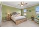 Comfortable bedroom with a king bed, ceiling fan, and windows. Relaxing coastal decor creates a serene atmosphere at 20279 Lagente Cir, Venice, FL 34293