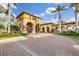 Elegant community clubhouse featuring arched entryways, manicured landscaping and a paver driveway at 20279 Lagente Cir, Venice, FL 34293