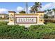 Community entrance with signage, decorative pillars, flowering bushes, and well-maintained shrubbery at 20279 Lagente Cir, Venice, FL 34293