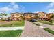 A row of attractive townhomes with brick driveways, lush lawns, and mature palm trees creating curb appeal at 20279 Lagente Cir, Venice, FL 34293