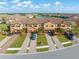 Exterior shot showcasing well-maintained townhomes, paver driveways, and manicured lawns in a community with a lake at 20279 Lagente Cir, Venice, FL 34293