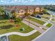 Beautiful townhomes featuring tile roofs, brick driveways, lush landscaping, and attached garages at 20279 Lagente Cir, Venice, FL 34293