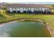 Back of the house with a cozy screened in patio overlooking a pond with a lush green lawn at 20279 Lagente Cir, Venice, FL 34293