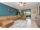 Bright living room with a leather sectional, tile flooring, and sliding glass doors to the outdoor living space at 20279 Lagente Cir, Venice, FL 34293