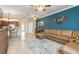 Cozy living room showcasing tile floors, a comfortable leather sofa, and a view of the entryway at 20279 Lagente Cir, Venice, FL 34293