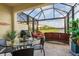 Inviting screened patio with outdoor dining set, grill and comfortable seating overlooking the water at 20279 Lagente Cir, Venice, FL 34293