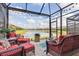 Serene screened patio with cozy seating, offering picturesque views of the tranquil pond and landscaping at 20279 Lagente Cir, Venice, FL 34293