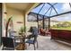 Inviting screened patio with outdoor dining set, grill and comfortable seating overlooking the water at 20279 Lagente Cir, Venice, FL 34293