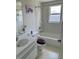 Bathroom featuring white tiles, window, and white sink and bathtub at 2259 Lee Ter, Port Charlotte, FL 33952