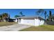 Home with a two-car garage, a well-maintained lawn, and a long concrete driveway at 2259 Lee Ter, Port Charlotte, FL 33952