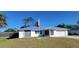 Charming single-story home featuring stone accents, an American flag, a well-maintained lawn, and a two-car garage at 2259 Lee Ter, Port Charlotte, FL 33952