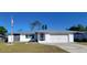 Charming single-story home featuring stone accents, an American flag, a well-maintained lawn, and a two-car garage at 2259 Lee Ter, Port Charlotte, FL 33952