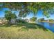 Scenic backyard with lush lawn, mature trees and waterfront view at 235 Caddy Rd, Rotonda West, FL 33947