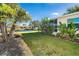 Landscaped backyard with view of the water and neighboring homes at 235 Caddy Rd, Rotonda West, FL 33947