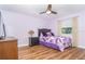 A calming bedroom with a full size bed, wood floors, ceiling fan and matching dark wood bedside table at 235 Caddy Rd, Rotonda West, FL 33947
