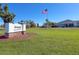 Rotonda Golf & Country Club entrance sign with the American flag waving at 235 Caddy Rd, Rotonda West, FL 33947