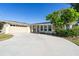 Wide driveway leading to a well-maintained home with stone accents and lush landscaping at 235 Caddy Rd, Rotonda West, FL 33947
