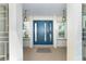Inviting front entrance featuring a blue door flanked by sidelight windows and stylish hanging lanterns at 235 Caddy Rd, Rotonda West, FL 33947
