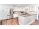 Modern kitchen with white cabinets, stainless steel appliances, and a granite island with cooktop at 235 Caddy Rd, Rotonda West, FL 33947