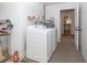 Bright laundry room featuring a white washer and dryer, shelving and water heater at 235 Caddy Rd, Rotonda West, FL 33947