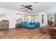 Inviting living room with a ceiling fan, comfortable blue seating, and wood-look flooring at 235 Caddy Rd, Rotonda West, FL 33947