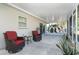 Covered patio featuring outdoor seating with red cushions, ceiling fan and view of backyard at 235 Caddy Rd, Rotonda West, FL 33947