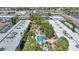 This aerial shows a condo community featuring mature trees, a swimming pool, and well-maintained landscaping at 2437 Harbor Blvd # 204, Port Charlotte, FL 33952