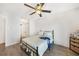 Bedroom with wood floors, decorative ceiling fan, and a black iron bed frame at 2437 Harbor Blvd # 204, Port Charlotte, FL 33952