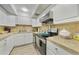 Bright kitchen with white cabinets, stainless steel appliances, and a stone tile backsplash at 2437 Harbor Blvd # 204, Port Charlotte, FL 33952