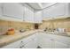 Kitchen featuring white cabinets and stone countertops with matching backsplash at 2437 Harbor Blvd # 204, Port Charlotte, FL 33952