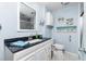 Clean bathroom featuring a modern vanity with black granite, a framed mirror, and a shower/tub in the background at 2955 N Beach Rd # D123, Englewood, FL 34223