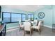 Bright dining area offers a glass table, seating for four, and expansive water views from large windows at 2955 N Beach Rd # D123, Englewood, FL 34223